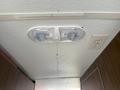Ceiling light fixture with two LED bulbs and a light switch in a 1976 GMC Motorhome interior