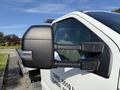Close-up of the side mirror of a 2022 Ford F600 with a black finish and integrated turn signal detail