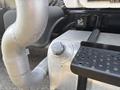 A close-up view of a 2010 Freightliner M2 106 showing a metal fuel tank with a cap and attached silver piping leading to the engine
