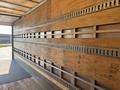 A 2012 Hino 338 truck interior showing wooden wall panels with metal load-securing rails along the sides
