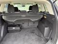 Interior view of the trunk of a 2015 Ford Escape showing a spacious area with floor covering and a black storage box on the left side