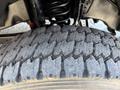 Close-up of a worn tire tread on a 2017 Ford F-550 showcasing deep grooves and cracks in the rubber surface