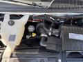 A close-up view of the engine compartment of a 2017 Chevrolet Express showing various components including hoses and a plastic reservoir