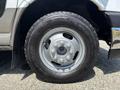 Close-up of a 2020 Chevrolet Express tire showcasing a silver wheel with distinctive lug nuts and a rugged tire tread design