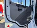 A close-up of the door panel of a 2011 Freightliner M2 106 featuring a textured gray surface and a black handle