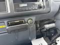 The interior dashboard of a 2001 Toyota Dyna featuring a radio, a storage compartment, and an ignition switch with a key slot above a button labeled press button and turn