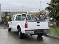 A white 2008 Ford F-250 Super Duty pickup truck with a metal bed rack visible in the rear