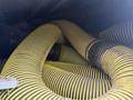 A collection of large yellow and black striped hoses coiled tightly together with some visible fittings and attachments