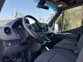 Interior view of a 2019 Mercedes-Benz Sprinter showing the steering wheel dashboard and front seats in a sleek black design