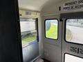 Interior view of a 2009 International 3000 CE school bus showing the emergency exit door and window with safety instructions displayed