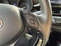 Close-up of the steering wheel of a 2021 Toyota C-HR featuring control buttons for trip information phone selection and cruise control settings