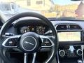 The interior view of a 2020 Jaguar XE showcasing the steering wheel dashboard and center console with touchscreen display and various controls