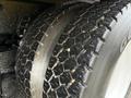 Close-up of a tire from a 2016 International 7400 showing a rugged tread pattern and some dirt on the surface