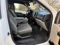 Interior of a 2018 Ford F-350 showing two front seats with gray fabric upholstery and a central console
