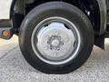 Close-up of a silver wheel and tire from a 2018 Hino 195 showcasing the bolt pattern and tread design