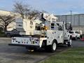 A white 2013 International Durastar 4300 service truck with an Altec aerial lift mounted on the back and various compartments for tools and equipment