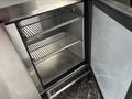 An empty stainless steel refrigerator with three wire shelves and a glass door closed