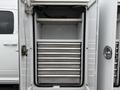 An open storage compartment of a 2024 RAM 5500 featuring multiple horizontal shelves for organizing tools and equipment