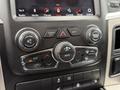 The dashboard control panel of a 2018 RAM 1500 with various knobs and buttons for climate control and audio settings