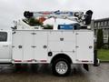 A white 2024 RAM 5500 service truck with a crane mounted on the bed and tool compartments on the sides