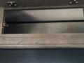 A wooden storage compartment with a metallic hinge inside a 2021 Jayco Jay Flight camper
