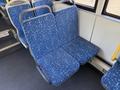 A pair of dark blue bus seats with a geometric pattern featuring white and light blue designs