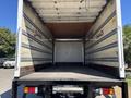 A 2022 Isuzu NQR truck with an empty cargo area featuring metal and wooden panels inside the truck bed