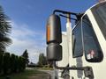 A 2012 International DuraStar 4300 truck featuring a large black cylindrical exhaust and a reflective orange light mounted on the side