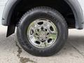 Close-up of a shiny chrome wheel rim and tire of a 2013 Chevrolet Express showcasing the Chevrolet logo and the tire brand GT Radial