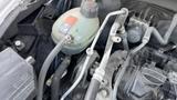 Close-up of the engine compartment of a 2019 Nissan Kicks showing various components including hoses and a reservoir tank
