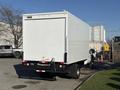 A 2010 Ford F-450 with a white box cargo area is parked with the rear facing the viewer showcasing the truck's distinctive shape and design