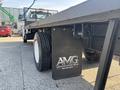 A 2018 Ford F-750 with a flatbed design showcasing the rear tires and a black branded mud flap with the text AMG on it