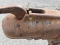 A close-up of a rusty metal hook with inscriptions showing the model number and weight rating of a JLG Industries 1014