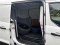 A 2019 Ford Transit Connect with its rear doors open showing two black tires inside the cargo area