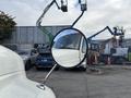 A 2012 International DuraStar 4300 truck is shown in the foreground with its side mirror reflecting a construction site in the background