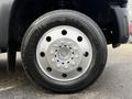 Close-up view of a 2012 Ford F-550 wheel featuring a silver rim with multiple circular cutouts and a black Continental HSR tire