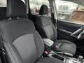 A 2016 Subaru Forester with black fabric seats and a central console featuring cup holders and storage compartments