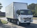 A 2018 Hino 195 box truck with a white exterior and budget rental markings on the side parked on a street