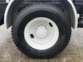 Close-up of a Michelin tire mounted on a white wheel belonging to a 2016 Freightliner 108SD truck