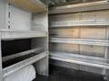 A 2017 RAM Promaster interior featuring metal shelving and storage space without any items on the shelves