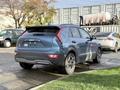A blue 2023 Kia Niro EV is showcased from the rear with a modern design featuring sleek lines and a compact silhouette