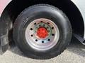 Close-up of a large tire from a 1992 Emergency One Typhoon Superior featuring a silver rim with red accents and a thick black tread