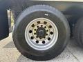 Close-up of a silver wheel on a 2013 International WorkStar truck featuring a black tire with visible tread and a multi-bolt hub design