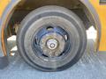 A close-up view of a wheel on a 2006 Thomas Saf-T-Liner HDX bus showing the tire tread and metal rim with visible bolts and a center cap