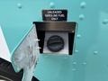 Fuel filler door of a 2020 Freightliner MT45 displaying a warning sign for unleaded gasoline fuel only with a black fuel cap visible