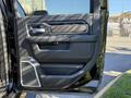 A close-up view of the interior door panel of a 2021 RAM 3500 featuring black leather and chrome accents with a handle and controls for windows and locks