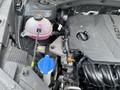 A 2022 Kia Sorento engine with visible components including a gray engine cover a pink coolant reservoir and a blue cap on a container