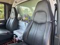Interior view of a 2007 GMC C4500 TopKick featuring two black leather seats and a control box with multiple switches and two mounted fans