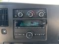 Dashboard of a 2019 GMC Savana featuring radio controls and climate control knobs with digital display showing time and radio station information