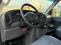Interior view of a 2007 Ford Econoline showing the dashboard steering wheel and center console with cup holders